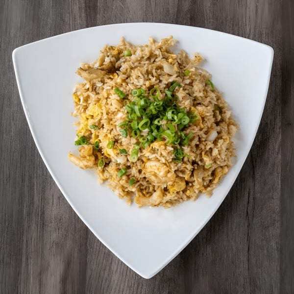 Zake Sushi & Ramen's shrimp fried rice, garnished with fresh green onions, on a white triangular plate.